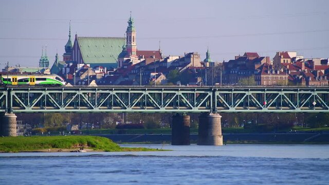 Panorama Warszawy w słoneczny dzień znad Wisły z okolic Żerania. Pociąg na moście kolejowym