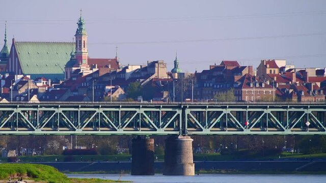 Panorama Warszawy w słoneczny dzień znad Wisły z okolic Żerania. Pociąg na moście kolejowym