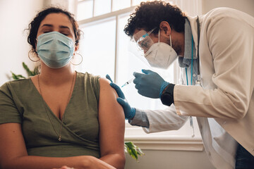 Woman with face mask getting vaccinated - obrazy, fototapety, plakaty