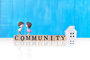 Community - word from wooden blocks with letters, group of people community concept, on blue wooden wall background