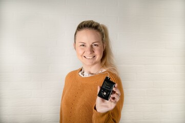 Attractive blonde woman holding her insulin pump - treating diabetes with technology