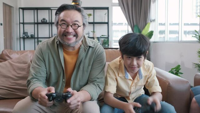 Son and dad playing video game at home