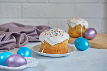 Easter cakes and colored eggs on a white table