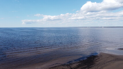 Aerial view of the shoals on the bay and the blue expanse of water to the horizon on a sunny spring day for a natural background