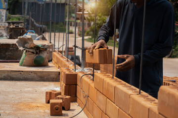 Builder carefully puts red brick on the masonry. Quick work bricklayer. Guy measures level masonry. Man is building brick wall. Correctly calculate material. Builder manually carries brick structure