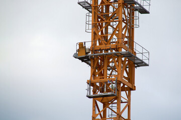 yellow construction crane close-up.construction of houses.against a cloudy sky