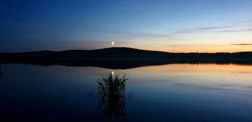 Radiant Sunset on the shore of the lake with a view of the grass