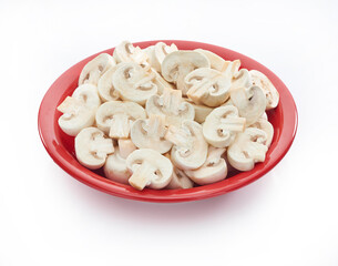 Sliced champignon mushrooms in red plate on white background, healthy eating for vegan people
