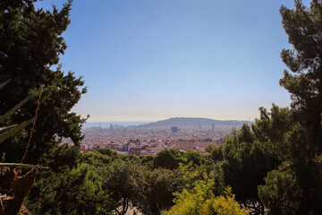 Fototapeta na wymiar Panoramic view of Barcelona from hill, greenery in the foreground, Mediterranean Sea in the background