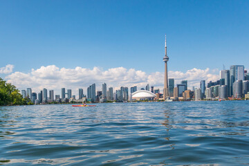 The Toronto skyline seen from the Toronto Islands with a sea kayaker in the middle foreground.