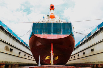 Ship moored on floating dry dock yard in shipyard under repair and maintenance on vintage tone