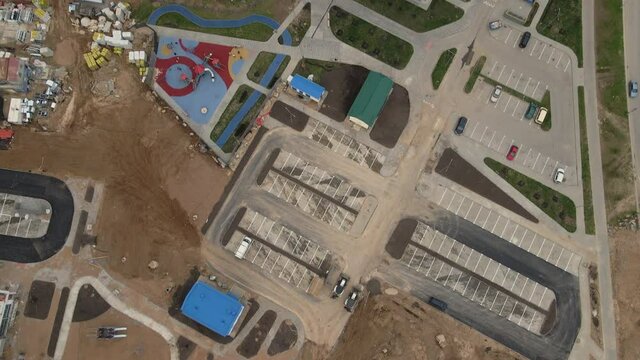 Flight over the construction site. Filmed with the camera down. Houses and communications are visible. Aerial photography.