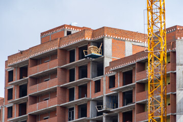 construction of a monolithic apartment building lined with red bricks