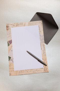 Briefbogen mit Ornamenten auf einem silberfarbenen Hintergrund. Dazu ein passender Briefumschlag und ein Kugelschreiber. Großes Textfeld