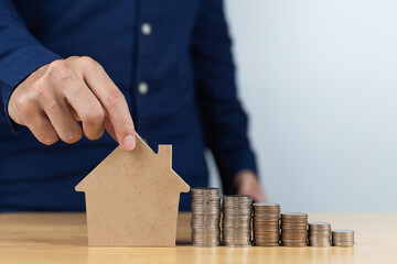 Businessman hold house model with coin stack. Concept for property, ladder, mortgage ,real estate investment and saving