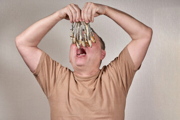 A man holds in his hands a lot of fish gnawed to the bone