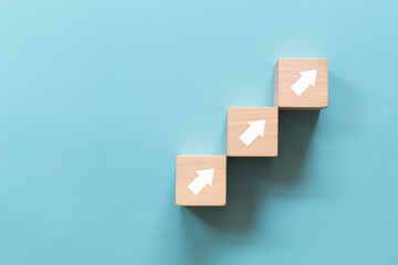Wooden cube with arrows pointing up on blue backgroun. Concept of business success growth increase up - obrazy, fototapety, plakaty