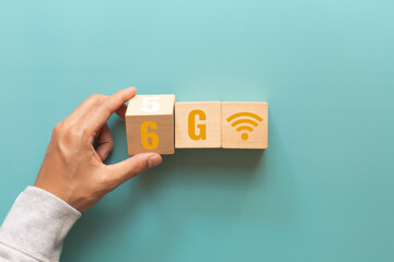 Hand flip wooden cube with the word 5G to 6G with wifi signs on green background. Connect global wireless devices