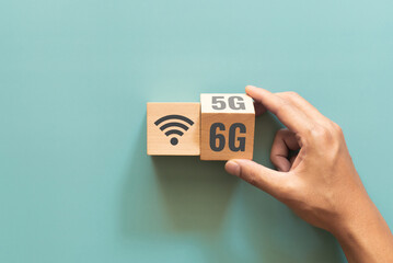 Hand flip wooden cube with the word 5G to 6G with wifi signs on green background. Connect global wireless devices