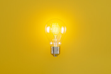 glowing classic light bulb with filament on yellow background, web banner or template, 3d rendering