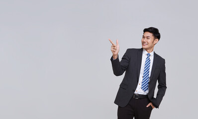 handsome and friendly face asian businessman smile in formal suit points his hands to presented to...