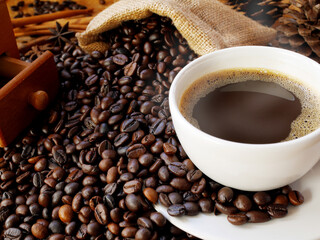 A cup of aroma coffee on a sack of coffee beans for drink in the morning