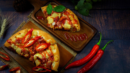 Delicious Italian Pizza with Red Chili And draw chili sauce on the wooden plan where the pizza is placed On a dark wood floor