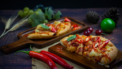 Delicious Italian Pizza with Red Chili And draw chili sauce on the wooden plan where the pizza is placed On a dark wood floor