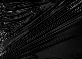 Obraz premium a transparent stretch plastic wrap on black background. realistic plastic wrap texture for overlay and effect. wrinkled plastic pattern for creative and decorative design.