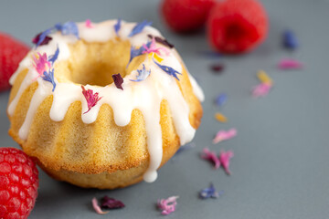 mini iced bundt cake blossoms and raspberries close up