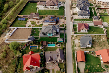 Aerial top view of a private house with paved yard with green grass lawn with concrete foundation floor
