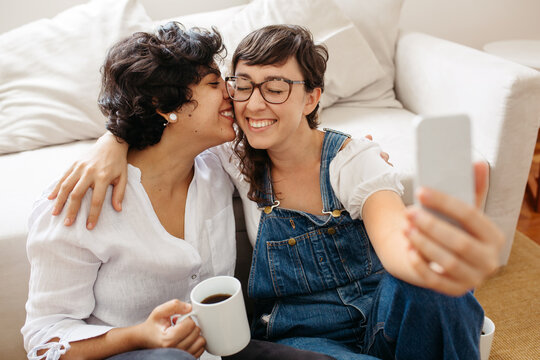 Lesbian couple taking selfie with phone
