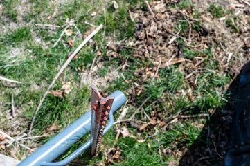 Focus on top of a steel fence, with the post driver blurred in the background below