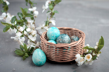 
Easter eggs in a basket close-up and spring cherry flowers