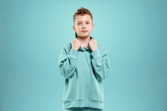 Portrait, cute stylish boy in a blue suit on a blue background. Studio portrait of a child, modern design, trendy background, turquoise. Copy space.