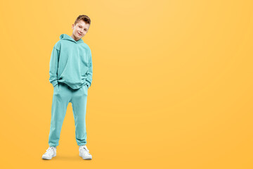 Fototapeta premium Cute stylish boy in a blue suit on a yellow background. Studio portrait of a child, modern design, trendy background.