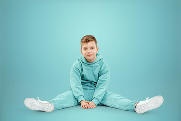 Portrait, cute stylish boy in a blue suit on a blue background. Studio portrait of a child, modern design, trendy background, turquoise. Copy space.