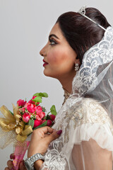 Portrait of a bride in a white wedding dress with a bouquet of pink  flowers in her hands Silhouette isolated on a studio white background. Asian type model