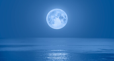 Naklejka na ściany i meble Full moon rising over empty ocean at night 