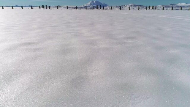 Snow-covered mountain plain and mountain in the distance