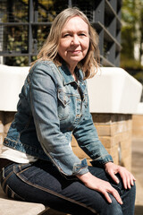 Mature blonde woman sitting and looking to camera.
