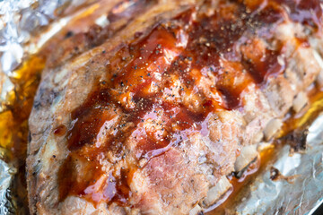 A large piece of Pork rib or spare rib grilled meat with BBQ sauce and pepper powder in full rack. Delicious cooked food object photo. Close-up and selective focus.