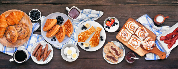 Fathers Day brunch table scene. Top view on a dark wood banner background. Tie pancakes, mustache...