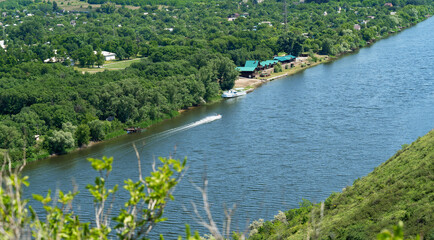 Tourist recreation center on the banks of the river. Spring water. Forest by the river, sunny summer day