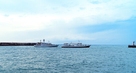 Yalta lighthouse, pleasure boat in the evening in the bay, Yalta, Crimea