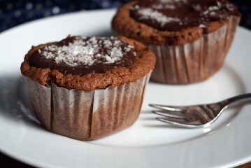 Two chocolate muffins on a white plate 