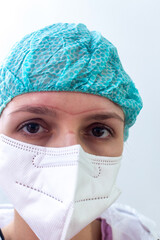 Portrait of a very tired young female doctor. A medical worker in a protective respirator and with traces of a mask on his face.