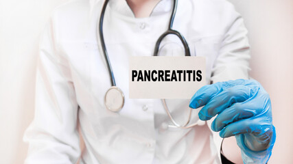 the doctor in gloves holds a card with the text PANCREATITIS . white background. the medicine