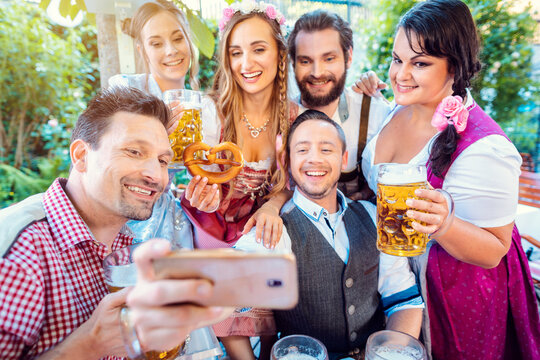 Cheerful group of friends taking a selfie in Bavarian beer garden