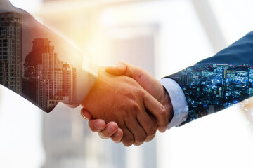 Investor. double exposure image of investor business man handshake with partner for successful meeting deal with during sunrise and cityscape background, investment, partnership, teamwork concept